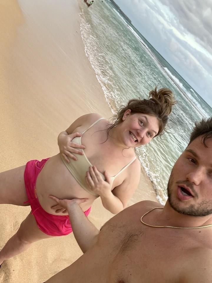 Pregnant woman shows her belly on beach