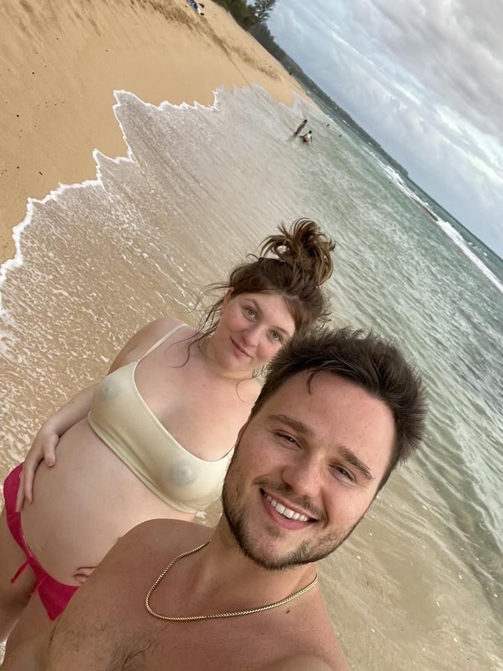 Pregnant woman shows her belly on beach