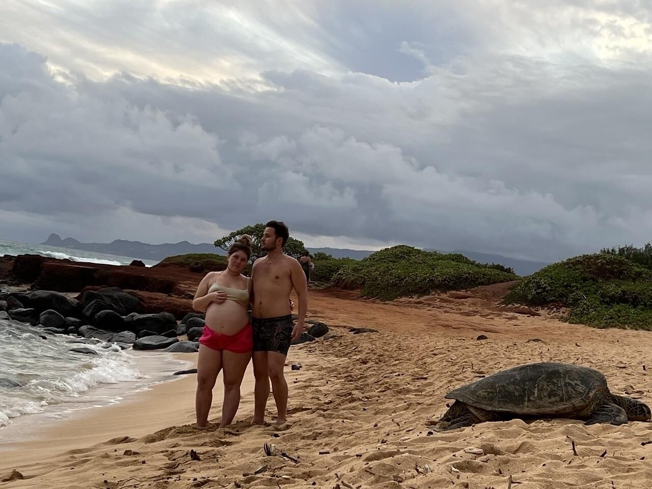 Pregnant woman shows her belly on beach